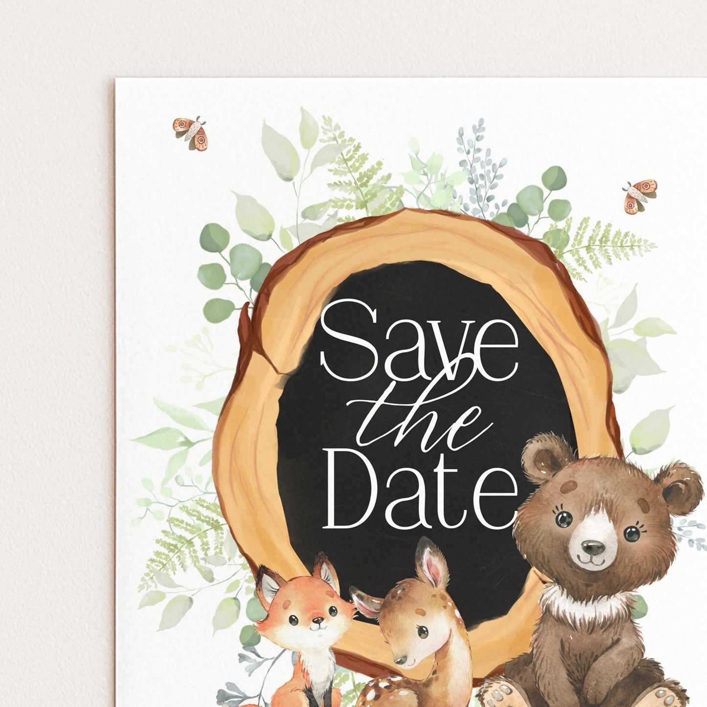 A white card with a black border, featuring illustrations of a bear, a fox, and a deer, along with the text "Save the Date" in the center.