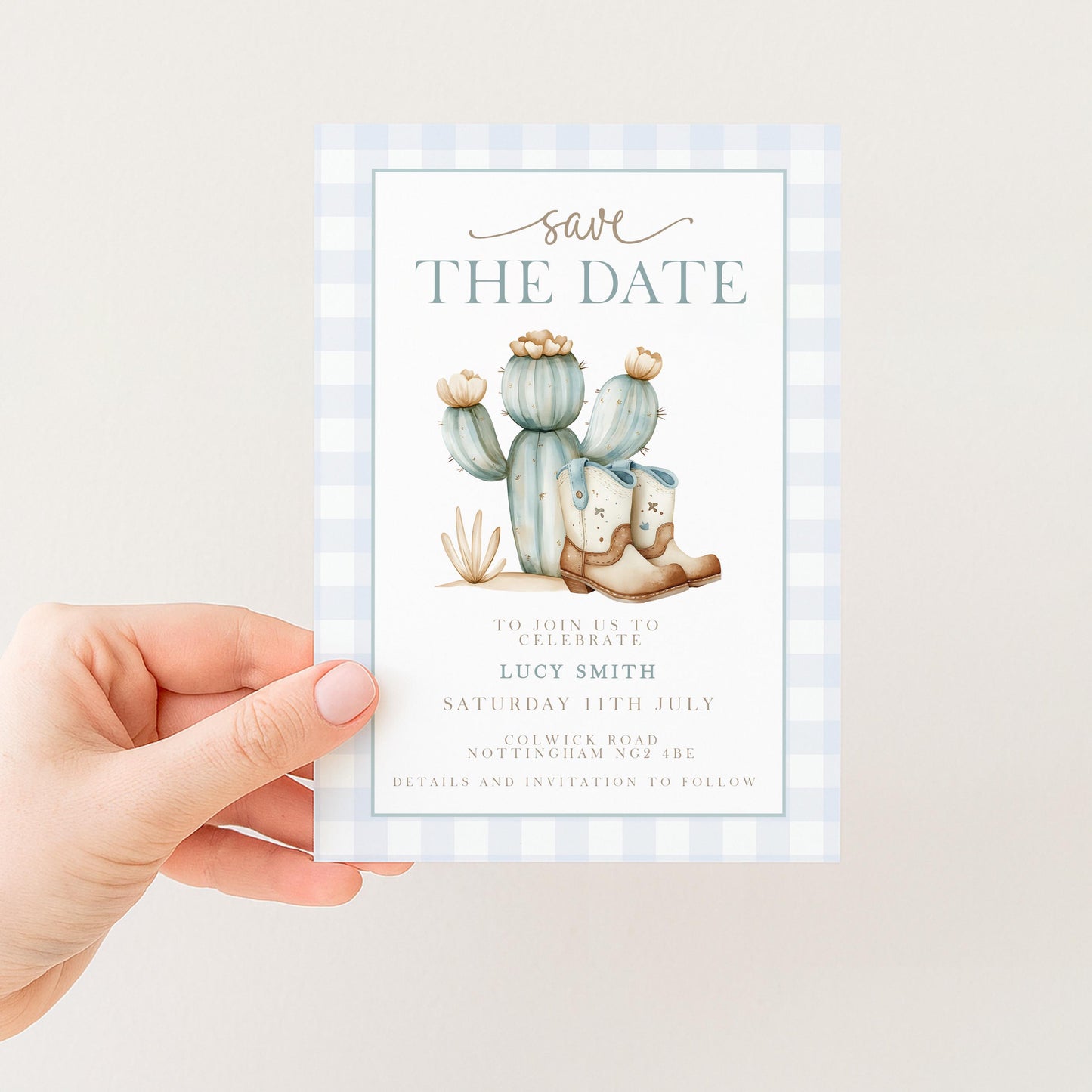 A hand holding a blue and white checkered wedding invitation card with a cactus illustration and the text "Save the Date" printed on it.