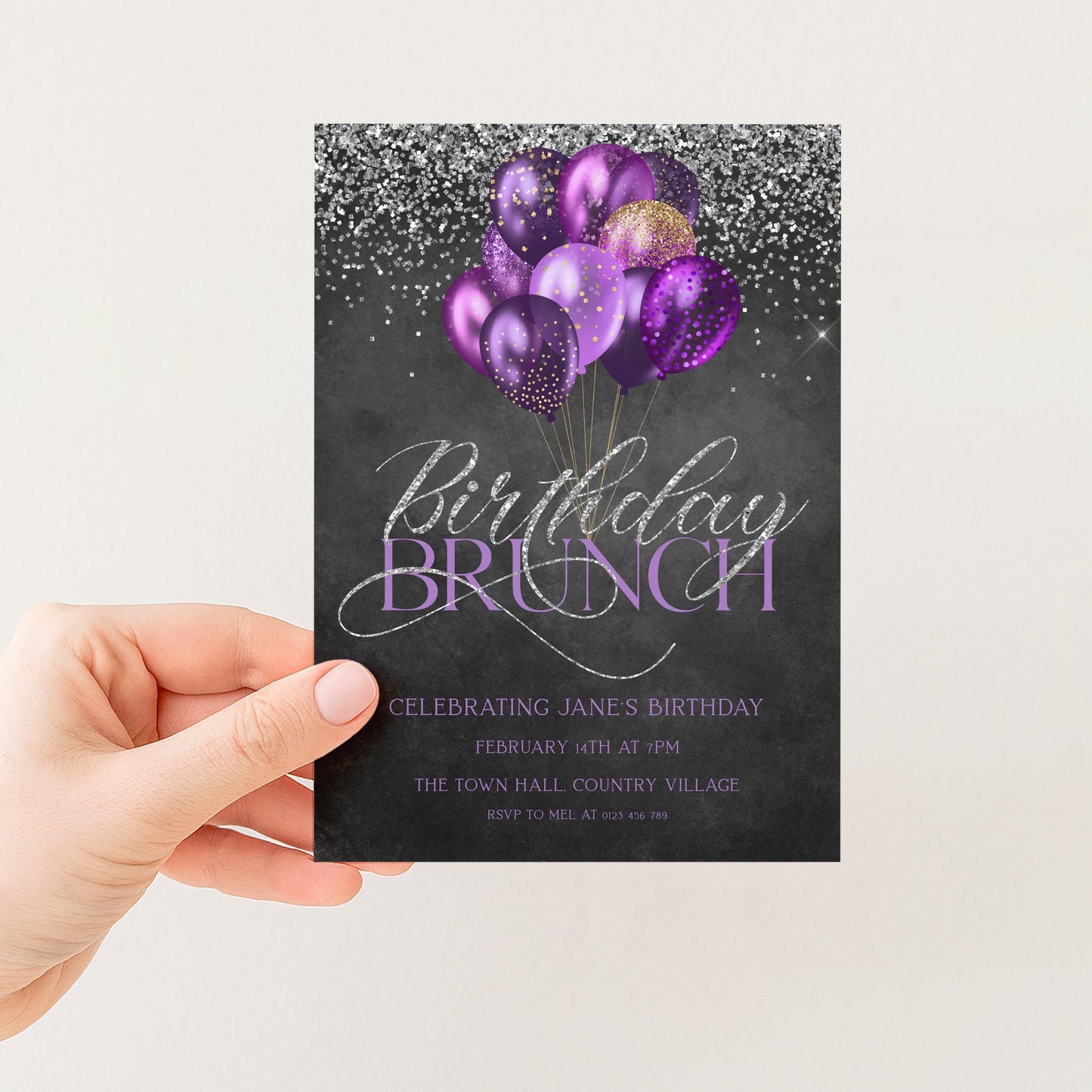 A hand holding a birthday party invitation card with a black background, purple balloons, and silver glitter.
