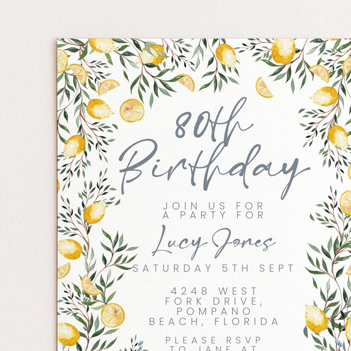 The image is a birthday invitation for a party for Lucy Jones, with a floral border and lemon-themed design.