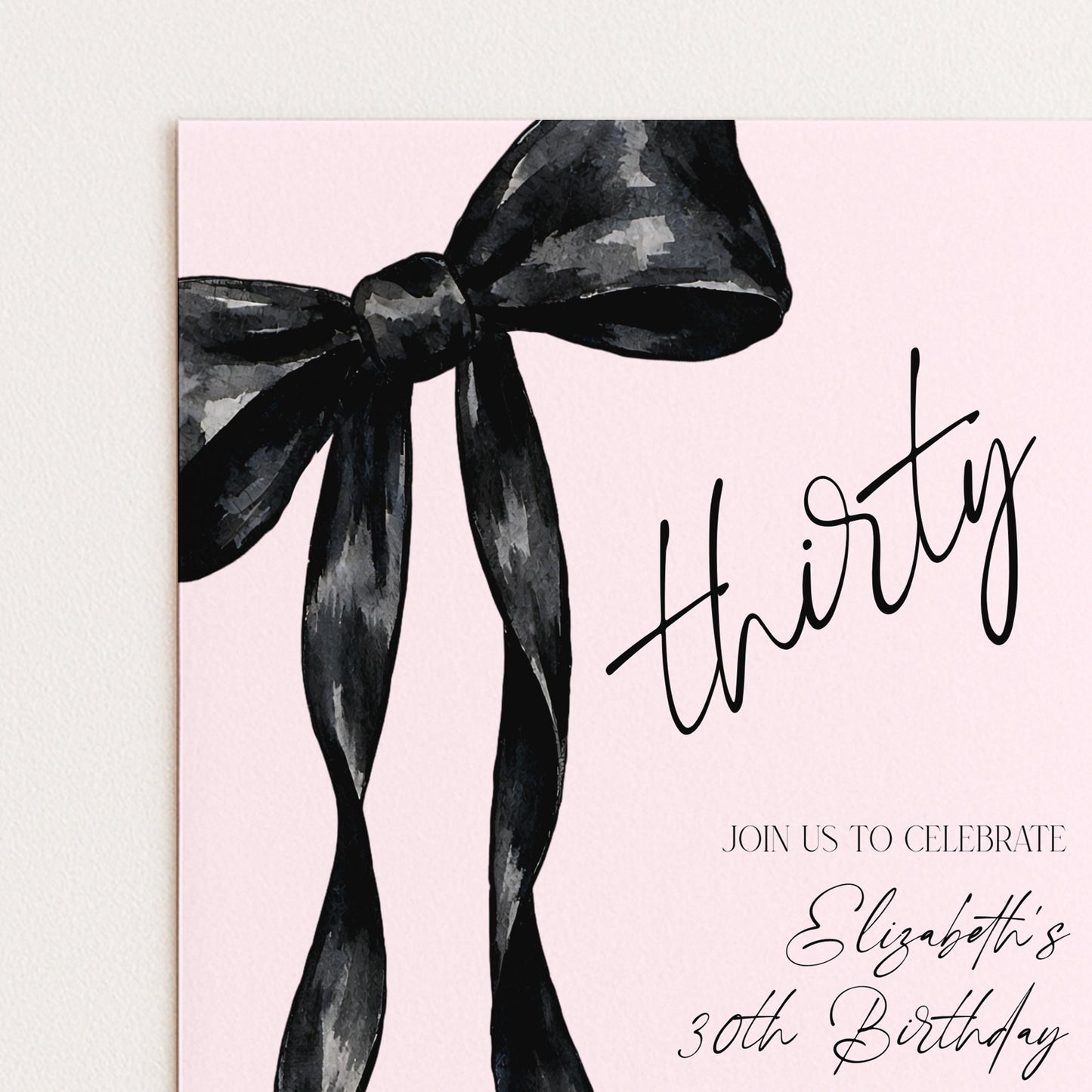 a pink background with a large black bow and the text "thirty" written in cursive.