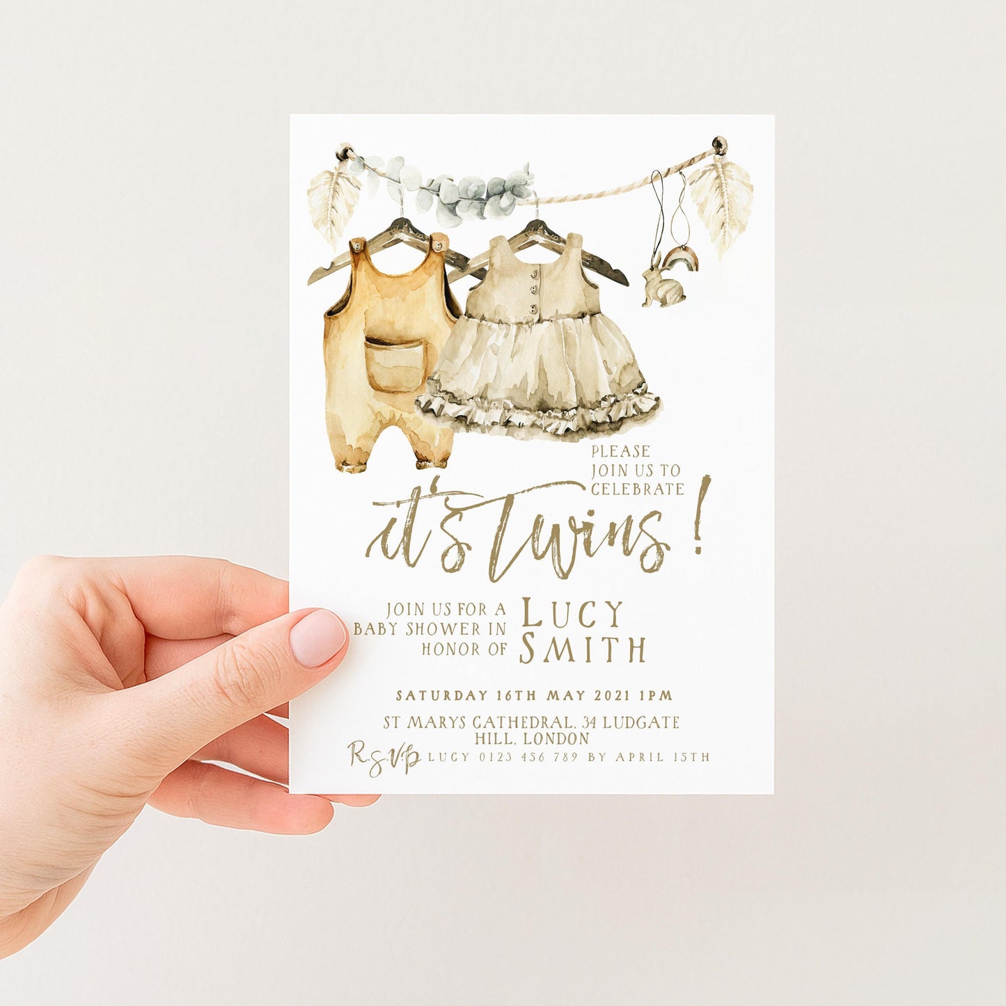 The image is a hand holding a baby shower invitation card.