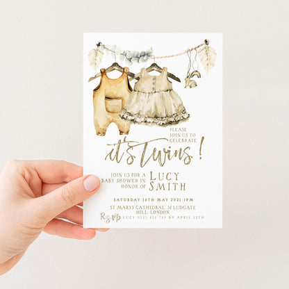 The image is a hand holding a baby shower invitation card.
