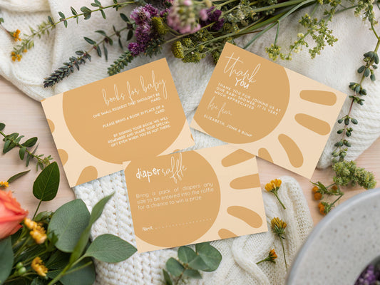three beige cards with text and a sun-like design, surrounded by greenery and flowers.