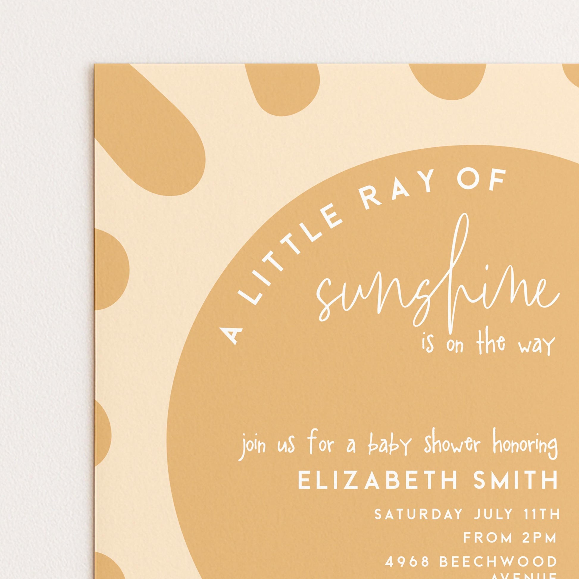 The image is a baby shower invitation with a sun-shaped design and text.