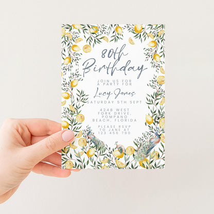 a person holding a birthday invitation card with a floral design featuring yellow flowers and leaves.