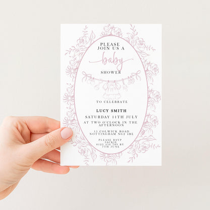 a person holding a white invitation card with a floral design. The card is for a baby shower and invites guests to celebrate with Lucy Smith on Saturday, July 15th at the Two-O'clock in the Nottingham Road, located at 12 Courtland Road, Nottingham NG2 4BE.