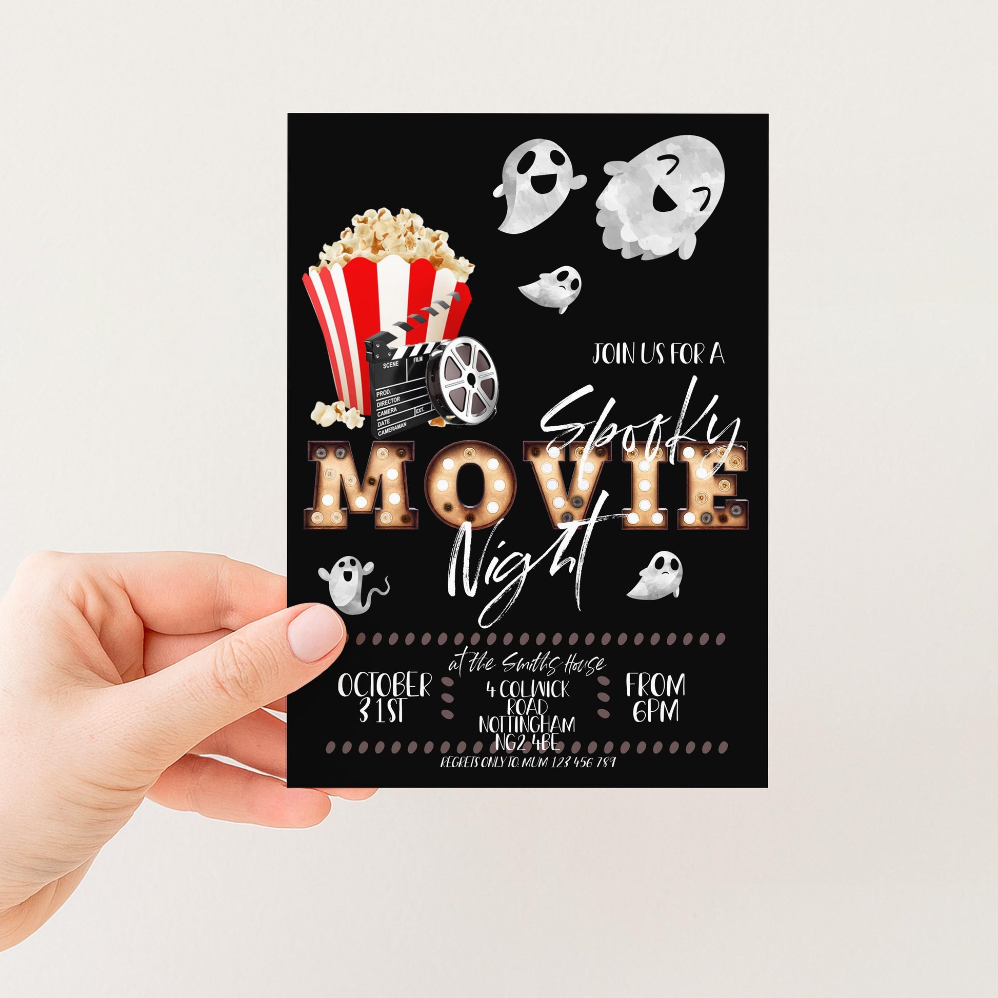 The image is a hand holding a black invitation card with a movie-themed design. The card features a popcorn bucket, a film reel, and ghostly figures, along with the text "JOIN US FOR A Spooky Movie Night" and event details such as the date, time, location, and contact information.