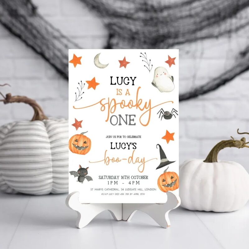 Halloween first birthday invitation with ghost, pumpkin, bat, and stars in orange and neutral tones for a spooky one-year-old party
